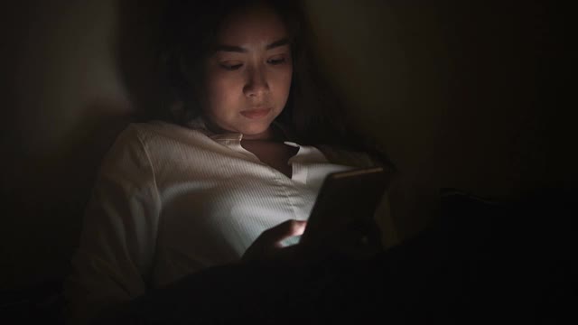 女性使用智能手机工作或在深夜上网。