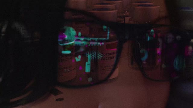 佩戴现代眼镜的女性智能眼镜和现实概念与Corona疫苗屏幕。虚拟技术。