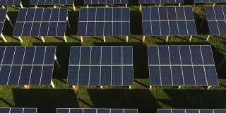 一架无人机在早晨通过太阳能电池飞行，阳光反射在它的身体上。太阳能电池被用于替代能源的应用。利用太阳能发电。
