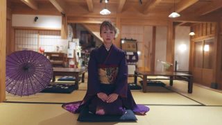 穿着Furisode和服的年轻女子坐在高跟鞋上，在日本的榻榻米房间鞠躬视频素材模板下载