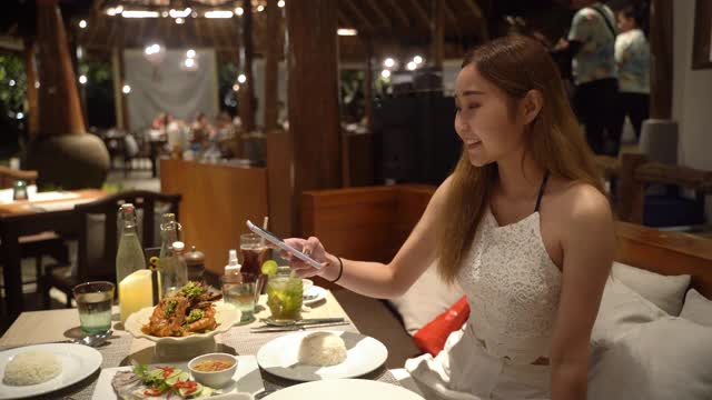 年轻女子在餐馆谈论食物的照片