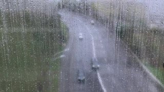 透过湿漉漉的窗户看马路上有雨滴，在雨中有人们的倒影视频素材模板下载