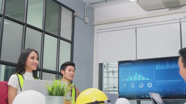 一群年轻的商业人士在办公室讨论会议后握手。男人和女人有交流头脑风暴和共同工作的项目作为团队。