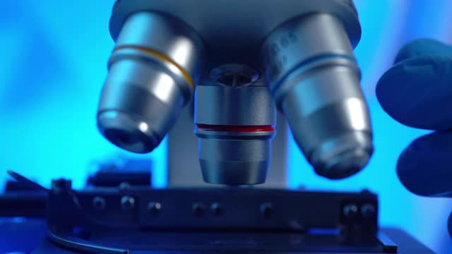 从病毒到实验室技术研究到冠状病毒或Covid-19的显微镜聚焦特写镜头。卫生保健研究人员在教室或科学实验室工作到很晚。科学家使用显微镜的概念。