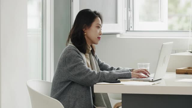 美丽的中国女商人视频会议使用笔记本电脑在家工作