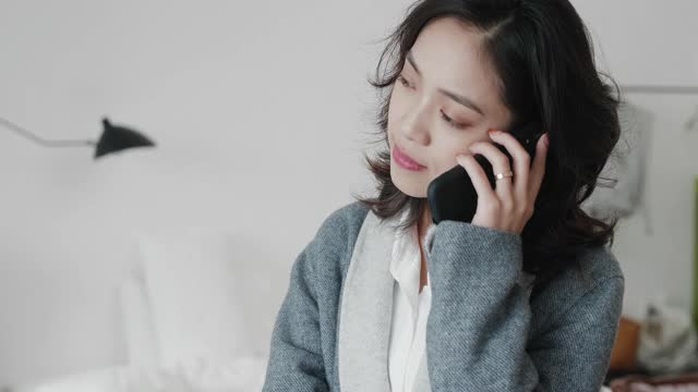 美丽的亚洲商务女性在电话中交谈