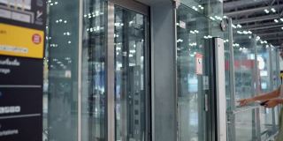 美女拿着智能手机和护照在透明电梯里