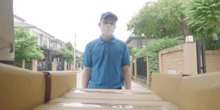 亚洲蓝色的送货员戴着防护面具和医用橡胶手套，搬运工卸货准备送往客户的货车