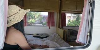 一个年轻的亚洲男人在度假的早上在露营车里给两个亚洲女人端咖啡