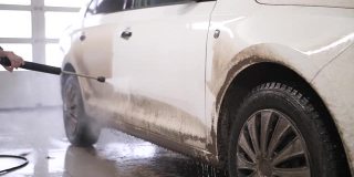 洗车。用泡沫洗车。洗车店的白色汽车。