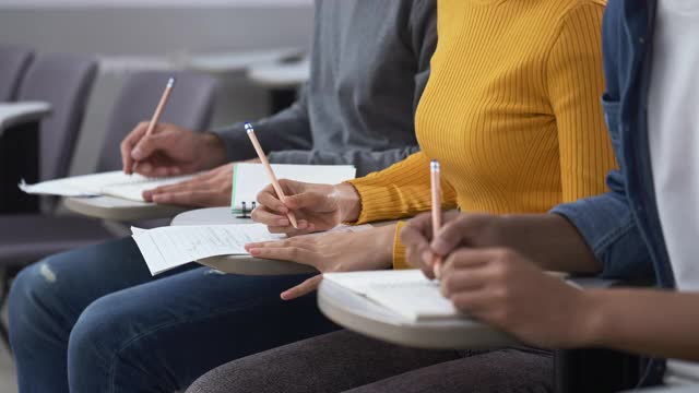 近距离观察大学生在教室里学习和写笔记