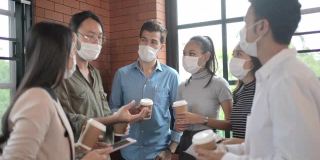 一群多种族的商务人士开会时戴上口罩以防止感染