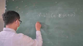 老师戴着面具站在教室前面，数学家正在大黑板上写字视频素材模板下载