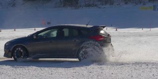 慢动作:一辆汽车粉碎雪的电影镜头，因为它沿着滑雪斜坡。