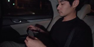 亚洲自由职业者坐在出租车司机车上用智能手机玩社交媒体