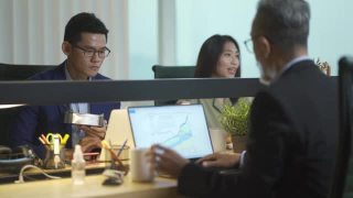 亚洲华裔年轻商人在办公室里工作，在他的工作场所用笔记本电脑做他的报告视频素材模板下载