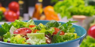 新鲜的沙拉，生菜叶和西红柿落在碗里