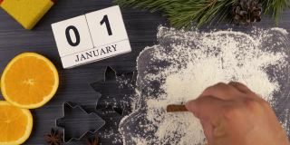 在2021年面粉上刻字。为圣诞节和新年准备节日大餐。日历，日期为1月1日。平面布局。饼干模具和面粉。