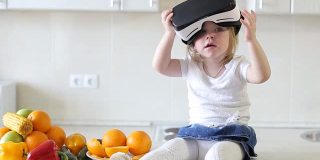 俄罗斯乌法——2017年4月:小女孩在厨房里使用虚拟现实眼镜