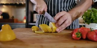 特写厨师在木切板上切柠檬。健康烹饪配料。国产菜系中柠檬草莓切片。酸黄的新鲜水果。烹饪素食新鲜食物4k