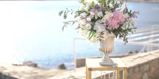 优雅的花瓶与一束牡丹，洋桔红，飞燕草和橄榄枝，婚礼场地装饰