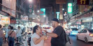 一对甜蜜的情侣在曼谷Yaowarat路享受街边小吃