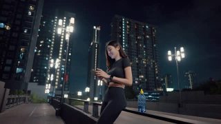美丽的运动员一边用智能手机跑步，一边在桥上等朋友视频素材模板下载