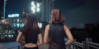 两个女运动员晚上在城市的街道上练习跑步。