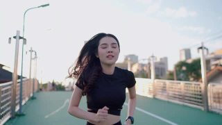自信的女跑步者在跑步后查看她的智能手表视频素材模板下载