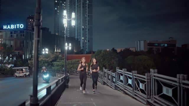 成功的女运动员晚上在城市的街道上练习跑步。