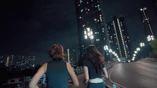 两个女运动员晚上在城市的街道上练习跑步。视频素材模板下载