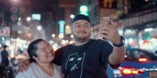 一对年轻夫妇正在享受街边小吃，并把照片发到社交媒体上