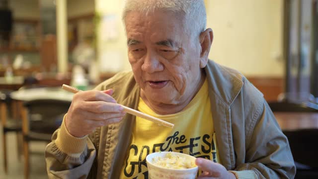 一个老人在中国餐馆吃饭。