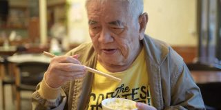 一个老人在中国餐馆吃饭。