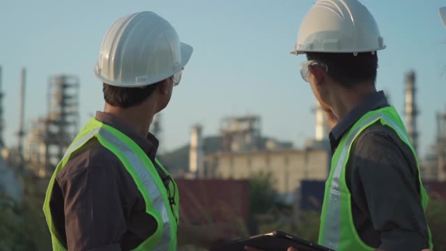 Engineers working with tablet at industrial, oil or gas plant