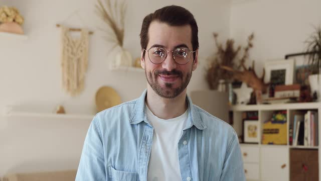 微笑的年轻英俊的男人戴着眼镜进行视频通话。