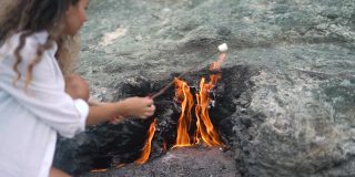 女士拿着棉花糖棒在chimmaera山火上