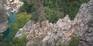 奇迈拉山岩石斜坡之间的绿松石河流