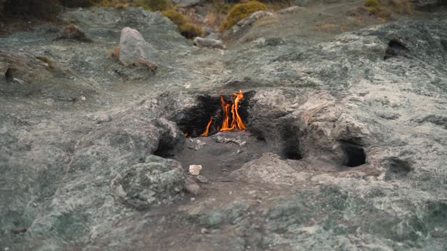 在奇迈拉山上灰色的岩石中燃烧着火焰