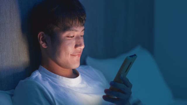 男人在晚上使用智能手机