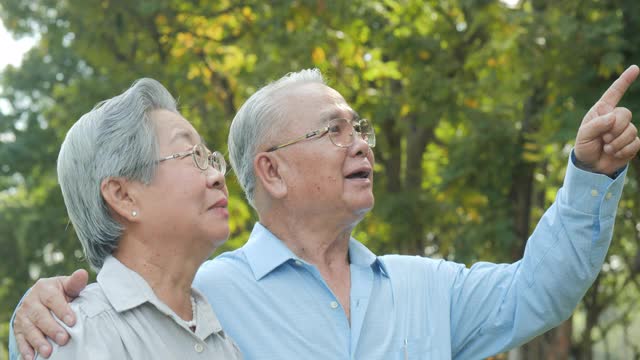 退休理念:亚洲老年男与老年女在公园交谈。