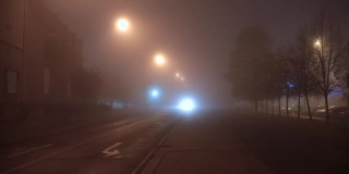 车头灯照亮了车辆行驶的道路。雾蒙蒙的夜晚。