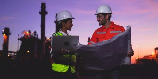 两个工厂工人用纸质文件和平板电脑检查和讨论工作技术