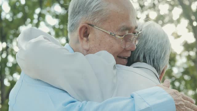 老夫妇在花园一起放松。他们相爱地拥抱在一起。