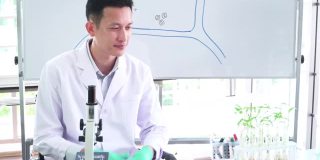 在生物实验室中使用光学显微镜研究微小植物细胞的科学实验的亚洲中部科学家，并在生物课上教授细胞的组成部分。研究人员正在分析蓝色液体作为创新的效果。