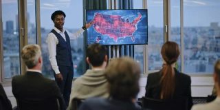 冠状病毒药研讨会。年轻的非洲裔医生展示美国疾病爆发地图