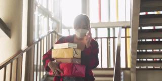 亚洲女人用手机戴着口罩拿着礼物盒