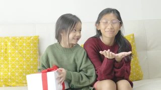 亚洲女孩在家里赠送礼盒给姐姐，庆祝节日节日。视频素材模板下载