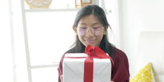 快乐的亚洲女孩在家里一起争夺礼盒，庆祝节日的概念。