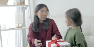 快乐的亚洲女孩在家里一起争夺礼盒，庆祝节日的概念。